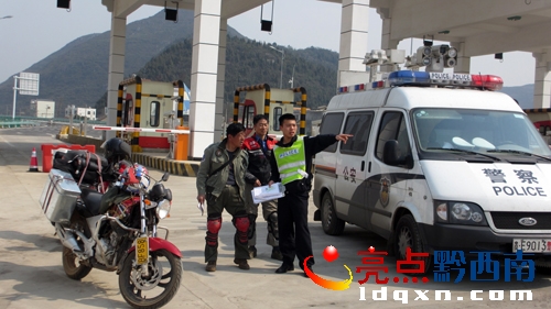 圖為出收費(fèi)站時(shí)民警為兩駕駛員指引去興義的路.jpg