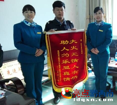 普安江西坡收費(fèi)站站長(zhǎng)蔣詠玲、副站長(zhǎng)劉寬麗將錦旗送到普安汽車站職工吳小龍手中.jpg